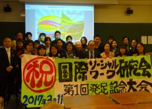 Attendees holding a banner at the launch of the The Japanese Association For The Study Of International Social Work