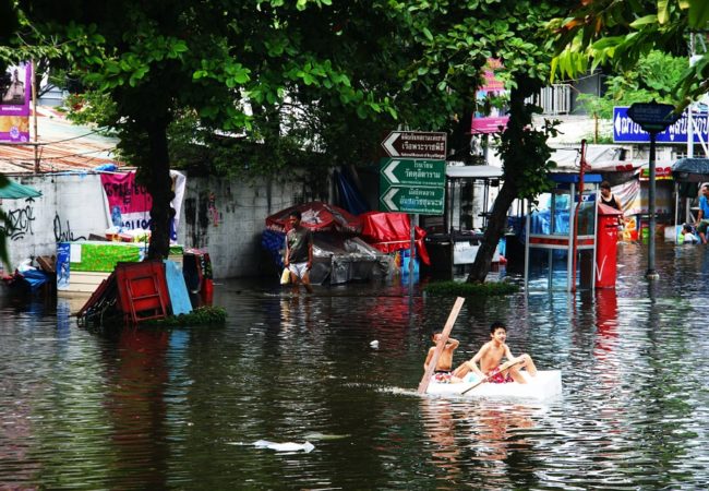 children on boat in flooded area