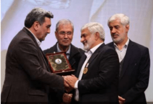 Tehran's Mayer is handing in the plaque of the event to Dr Vaez Mahdavi- Former ministry of Labor, co- op, and Social welfare and deputy of Tehran Municipality observing.